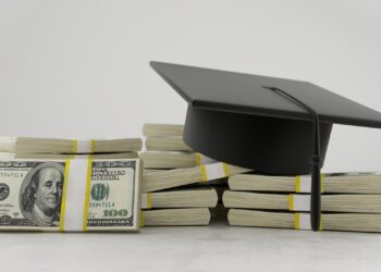Üzerinde mezuniyet kepi bulunan dolar demetleri ve burs parası temsil eden yığınlar.