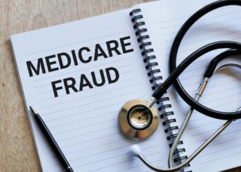 Açık bir defter üzerinde Medicare Fraud yazısı ve yanında siyah stetoskop.