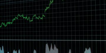 Yeşil renkli yükselen borsa grafiklerinin yer aldığı siyah ekran.