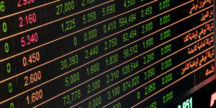 Siyah elektronik ekranda yeşil ve kırmızı renkli borsa verileri yer alıyor.