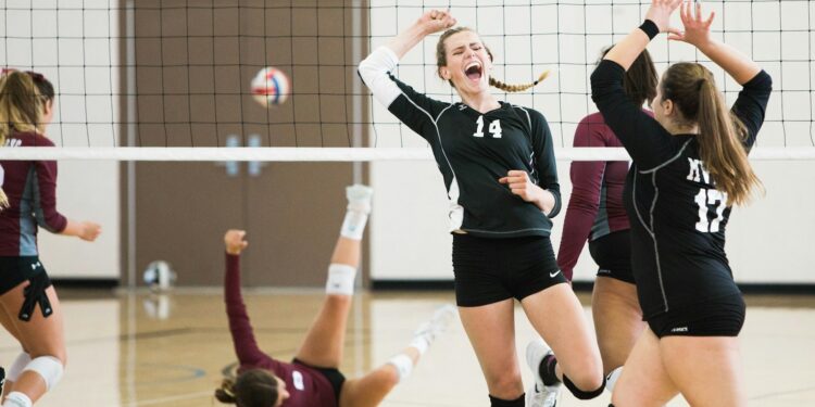 Salonda sayı sevinci yaşayan siyah formalı profesyonel kadın voleybol takımı