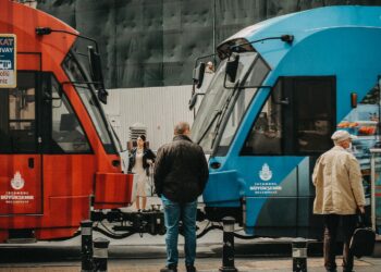 İstanbul sokaklarında karşılıklı duran kırmızı ve mavi şehir içi tramvayları.