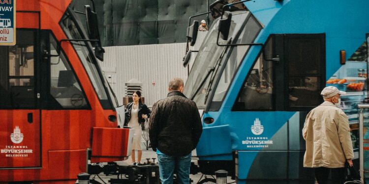 İstanbul sokaklarında karşılıklı duran kırmızı ve mavi şehir içi tramvayları.