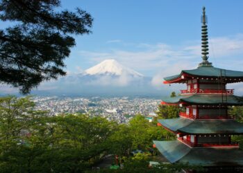 Ağaçların arasından görünen Chureito Pagodası ve arkasındaki karlı Fuji Dağı manzarası