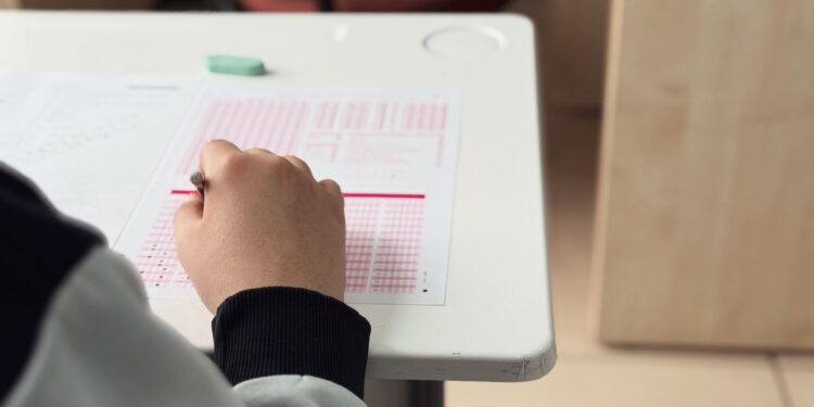 Sınavda optik form dolduran bir öğrencinin eli ve masası.