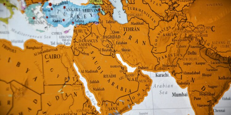 Orta Doğu'yu ve çevresindeki ülkeleri gösteren turuncu tonlarında büyük bir dünya haritası.