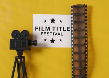 Sarı arka plan önünde eski bir film kamerası ve film şeridi