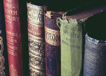 Koyu renk arka planda yan yana duran eski ve ciltli kitaplar