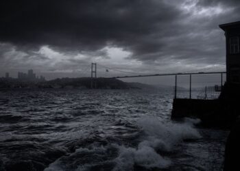 Fırtınalı günde İstanbul boğazında dalgalar ve köprü manzarası.