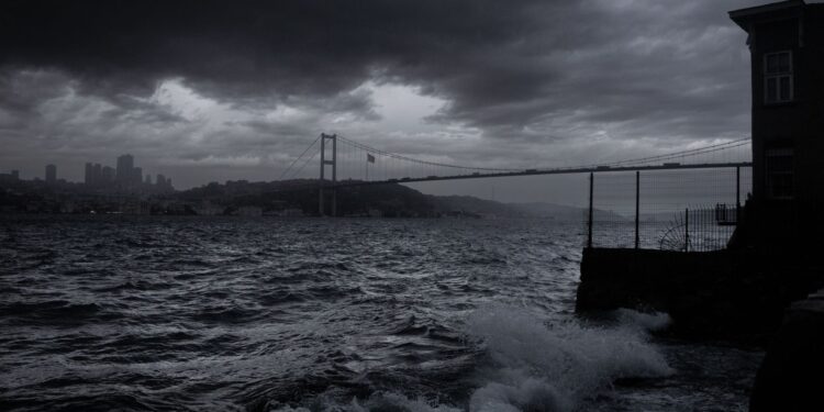 Fırtınalı günde İstanbul boğazında dalgalar ve köprü manzarası.